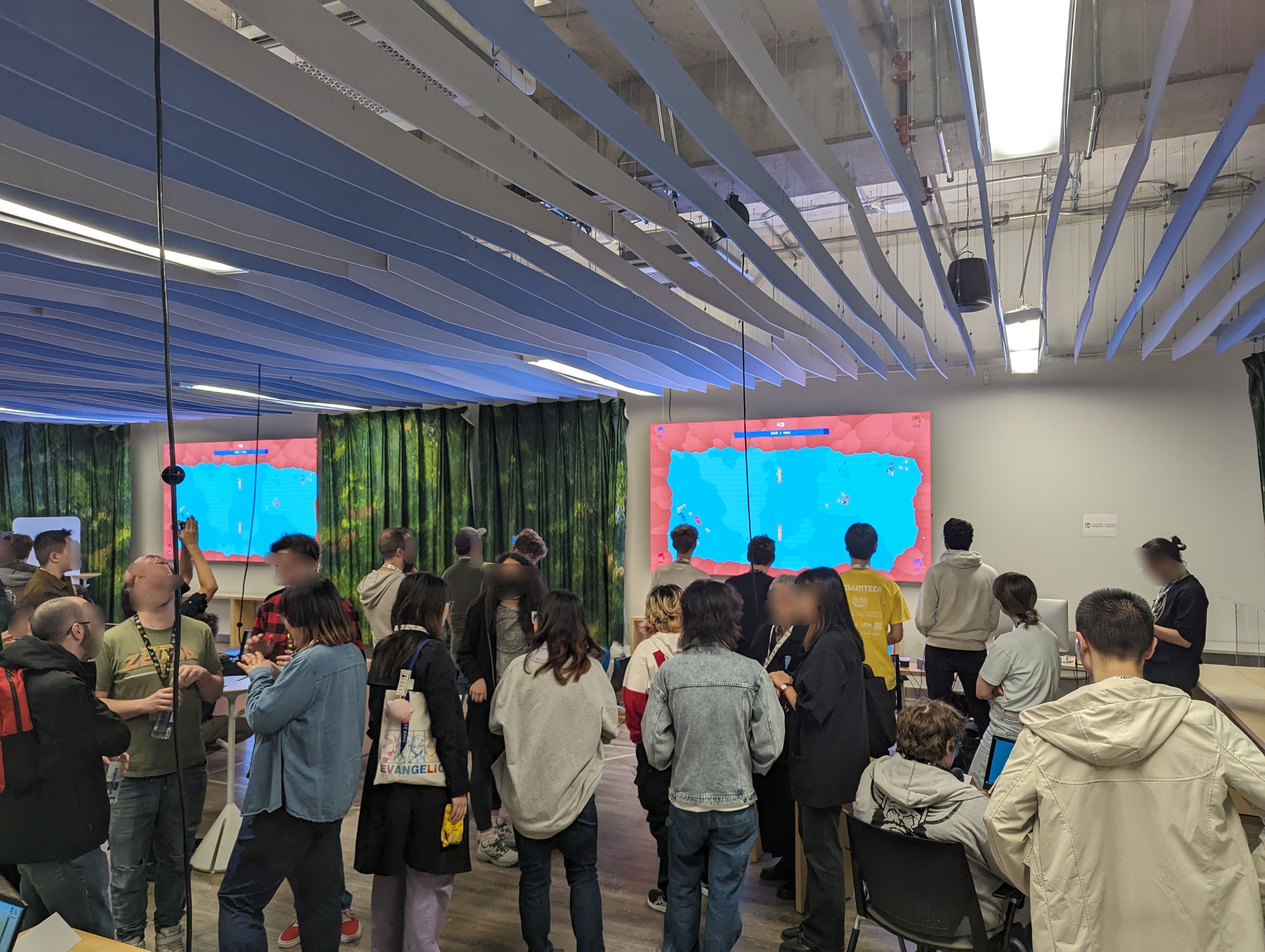 Some folks playing the game on the big screen at the arcade